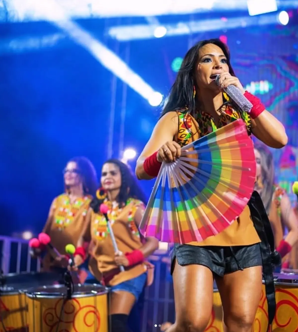Jullie Morato cantando com leque colorido